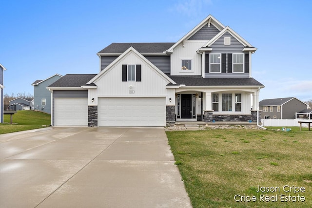 view of front of house featuring a front lawn, fence, stone siding, and concrete driveway