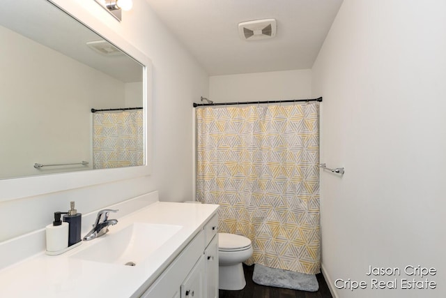 full bath with curtained shower, vanity, toilet, and wood finished floors