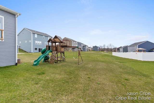 exterior space featuring fence, a residential view, and a lawn