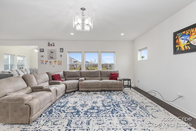 living room with wood finished floors, ceiling fan with notable chandelier, baseboards, and recessed lighting