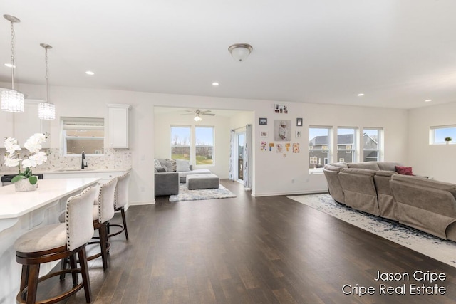 living room with ceiling fan, baseboards, dark wood finished floors, and recessed lighting