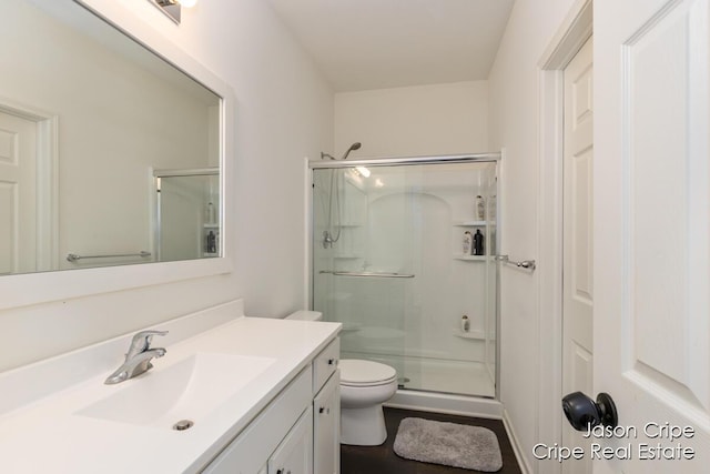 bathroom featuring toilet, vanity, visible vents, and a stall shower