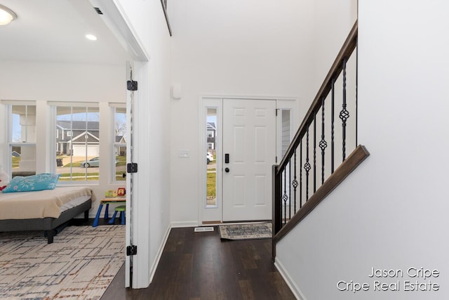 foyer entrance with baseboards, wood finished floors, recessed lighting, and stairs