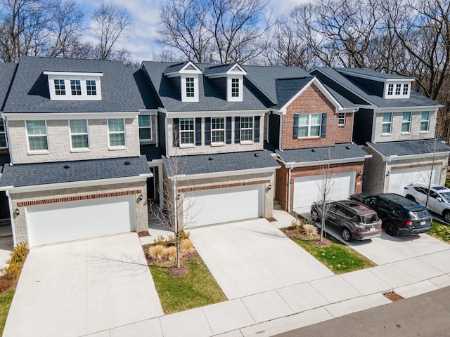 multi unit property with a residential view, an attached garage, roof with shingles, and driveway