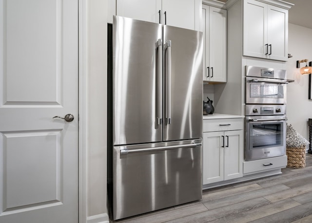 kitchen featuring appliances with stainless steel finishes, light wood-style floors, and light countertops