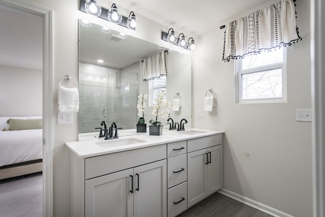 bathroom with visible vents, a sink, a shower stall, and double vanity