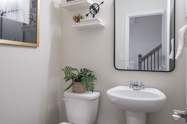 half bathroom featuring toilet and a sink