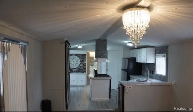 50594 Oregon Ave, Novi, MI 48374 - kitchen with an inviting chandelier, freestanding refrigerator, vaulted ceiling, white cabinets, and a sink