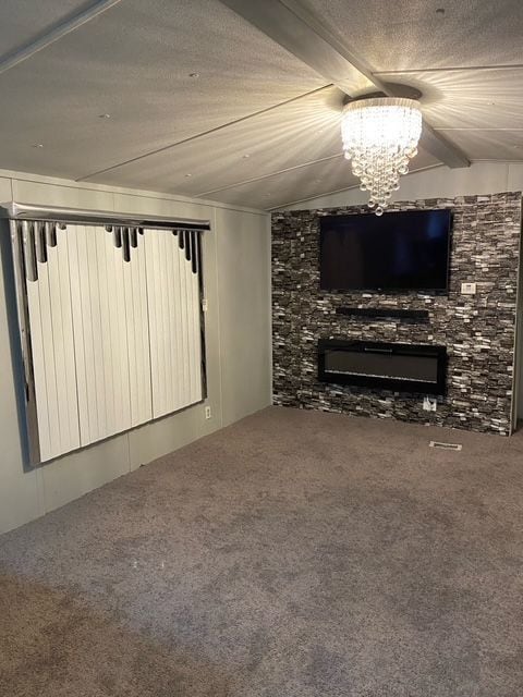 50594 Oregon Ave, Novi, MI 48374 - living area featuring a chandelier, a fireplace, carpet, and lofted ceiling