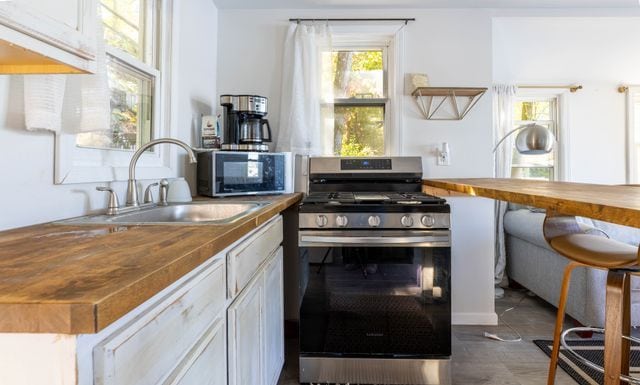 520 Bellevue Ave, Lake Orion, MI 48362 - kitchen with wood counters, a sink, and stainless steel gas stove