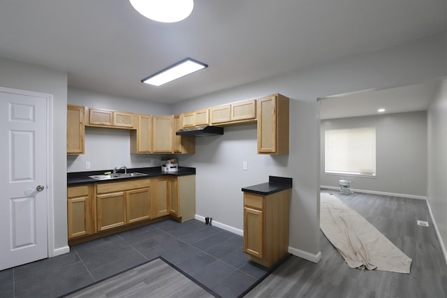 kitchen with dark countertops, light brown cabinets, baseboards, and dark wood-type flooring