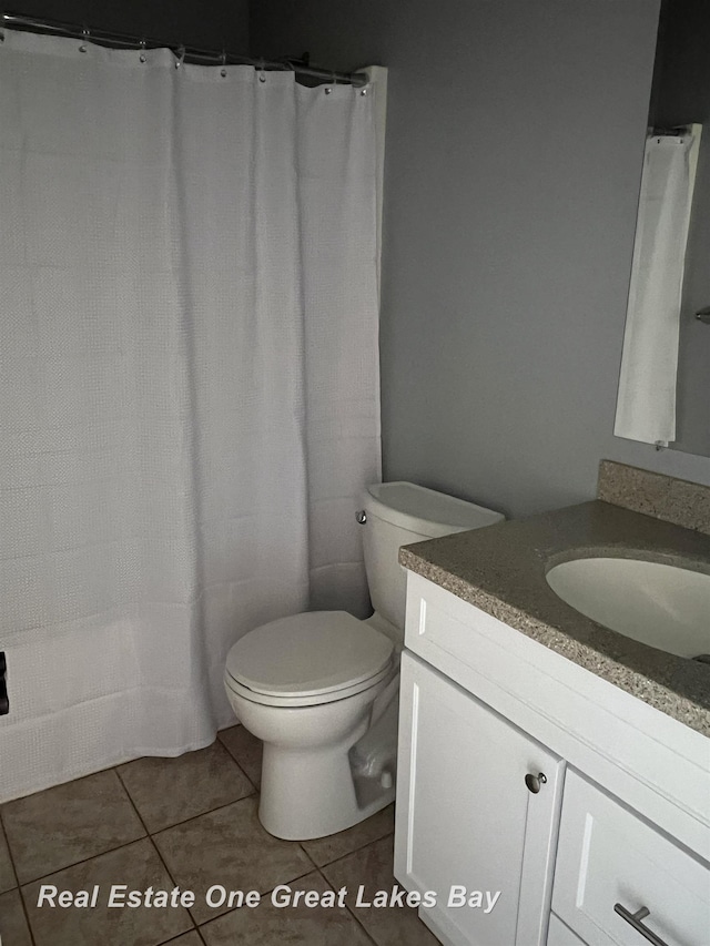 full bathroom featuring vanity, tile patterned floors, and toilet