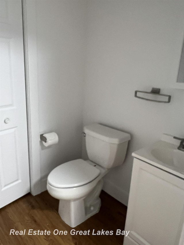 bathroom with vanity, baseboards, toilet, and wood finished floors
