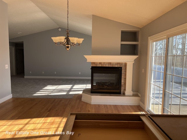8311 Goldfinch Rd, Freeland, MI 48623 - unfurnished living room with lofted ceiling, plenty of natural light, a chandelier, wood finished floors, and a fireplace