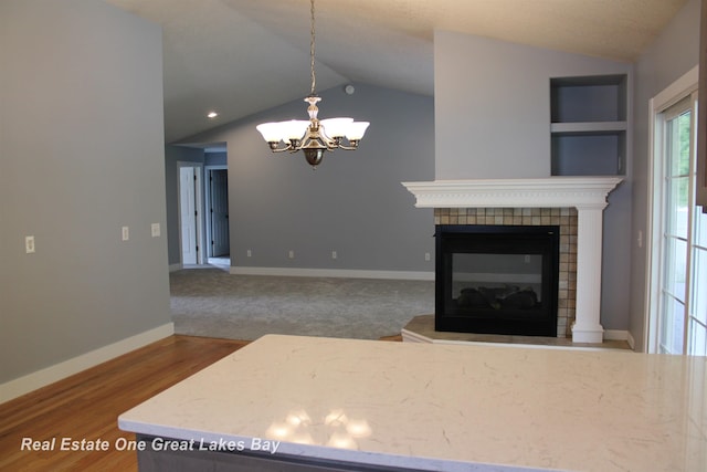 8311 Goldfinch Rd, Freeland, MI 48623 - living area with lofted ceiling, a chandelier, and a tiled fireplace