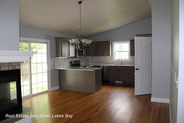 8311 Goldfinch Rd, Freeland, MI 48623 - kitchen featuring appliances with stainless steel finishes, lofted ceiling, backsplash, a chandelier, and a peninsula