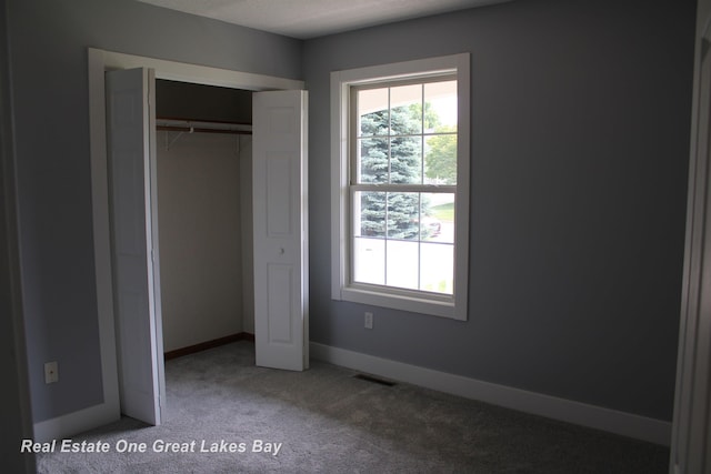 8311 Goldfinch Rd, Freeland, MI 48623 - unfurnished bedroom featuring multiple windows, carpet, and a closet