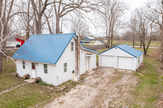 327 E Main St, Vermontville, MI 49096 - view of front of home featuring an outdoor structure, a detached garage, and metal roof