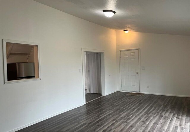 327 E Main St, Vermontville, MI 49096 - empty room featuring high vaulted ceiling, baseboards, and dark wood-style floors