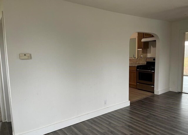 327 E Main St, Vermontville, MI 49096 - interior space featuring baseboards, arched walkways, and dark wood-type flooring