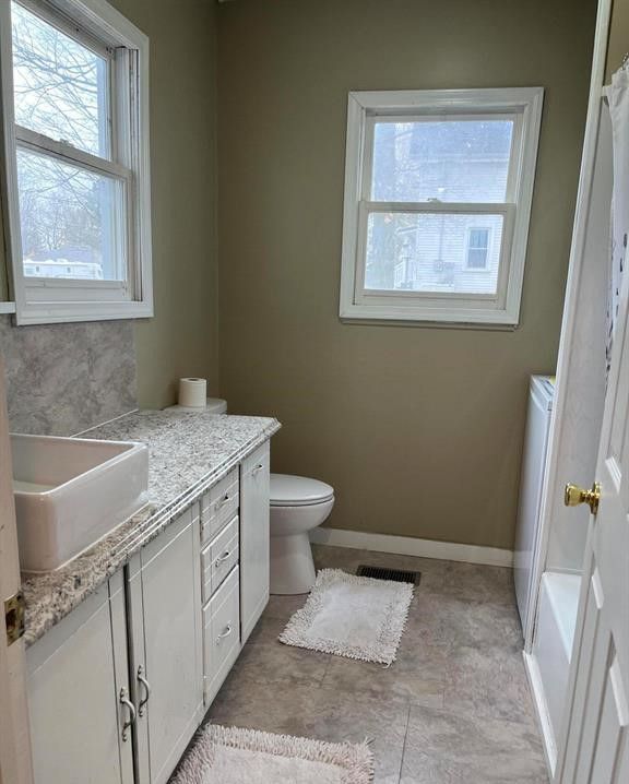 327 E Main St, Vermontville, MI 49096 - full bath featuring visible vents, toilet, vanity, washer / dryer, and baseboards