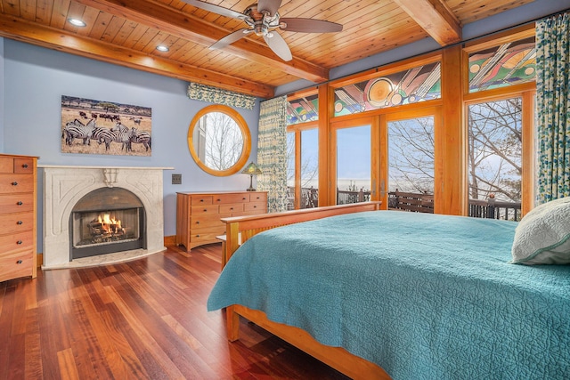 bedroom with wood ceiling, a high end fireplace, wood finished floors, and beamed ceiling