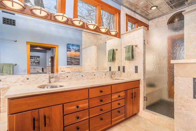 full bathroom featuring a sink, an ornate ceiling, decorative backsplash, and a stall shower