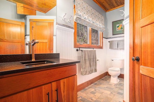 bathroom featuring tile patterned floors, a wainscoted wall, toilet, wood ceiling, and vanity