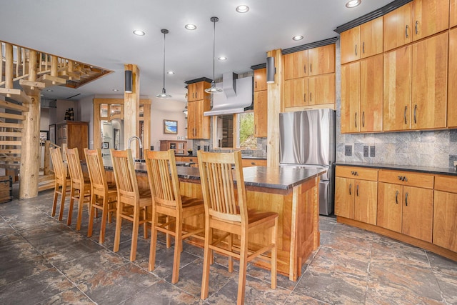 kitchen featuring a kitchen bar, extractor fan, dark countertops, and freestanding refrigerator