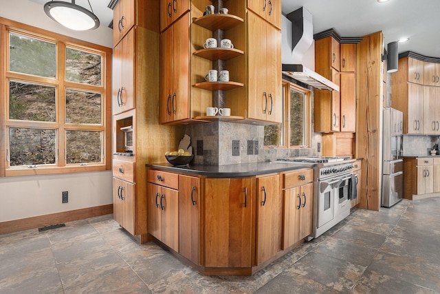 kitchen featuring wall chimney range hood, visible vents, appliances with stainless steel finishes, baseboards, and backsplash