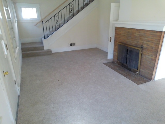 802 Oakridge Dr, Jackson, MI 49203 - unfurnished living room with carpet floors, a fireplace, and stairway