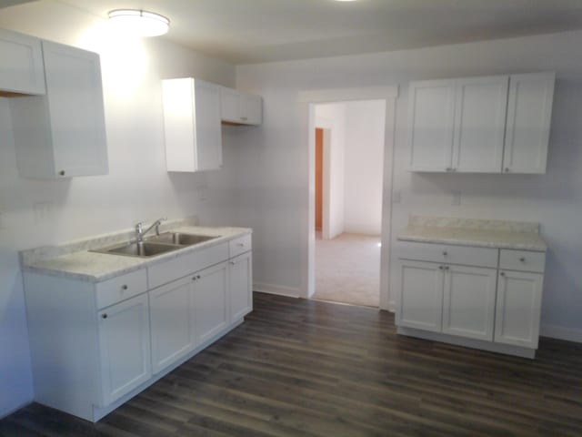 802 Oakridge Dr, Jackson, MI 49203 - kitchen featuring a sink, dark wood-style floors, white cabinets, and baseboards