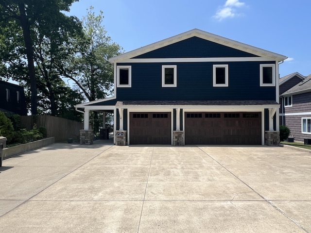 940 E Eagle Lake Dr, Kalamazoo, MI 49009 - view of front of house featuring a garage, concrete driveway, and stone siding