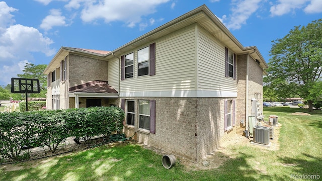 61043 Greenwood Dr # 167, South Lyon, MI 48178 - rear view of house featuring brick siding and a yard