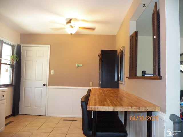 7303 Cranbrook Dr, Lambertville, MI 48144 - interior space featuring a wainscoted wall, ceiling fan, and light tile patterned flooring