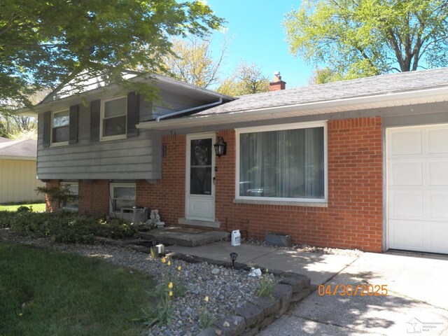 7303 Cranbrook Dr, Lambertville, MI 48144 - tri-level home with brick siding, a garage, and a chimney