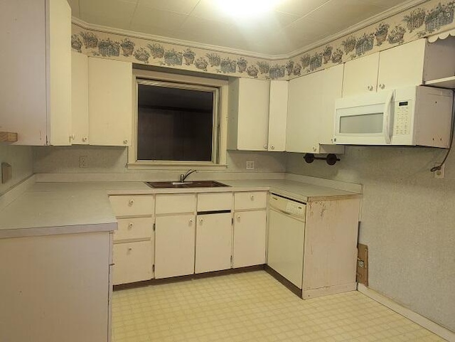 kitchen with a sink, white appliances, light floors, light countertops, and white cabinets