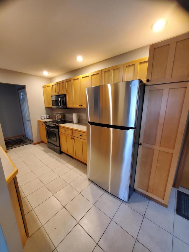 2109 Appleway Dr, Jackson, MI 49203 - kitchen with stainless steel appliances, light tile patterned floors, recessed lighting, light brown cabinets, and light countertops