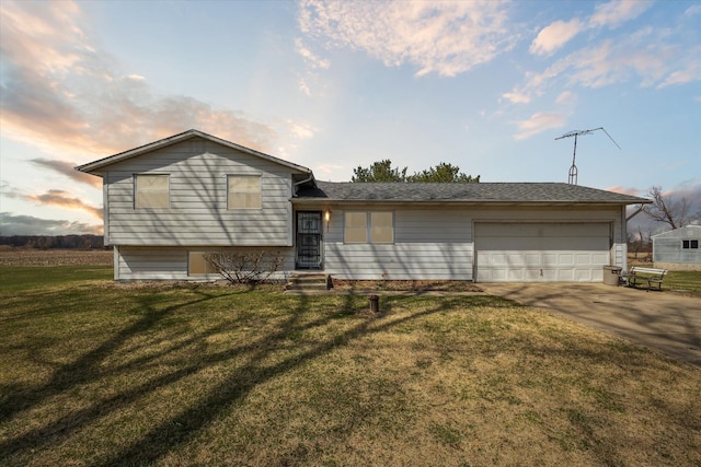 tri-level home with an attached garage, driveway, and a front yard