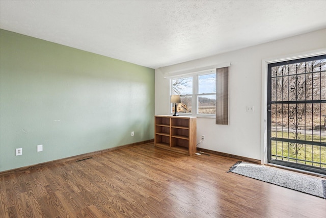 empty room featuring baseboards and wood finished floors