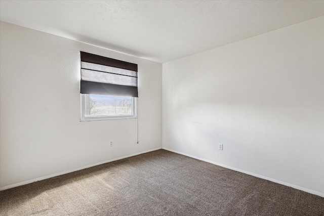 carpeted spare room with baseboards and visible vents