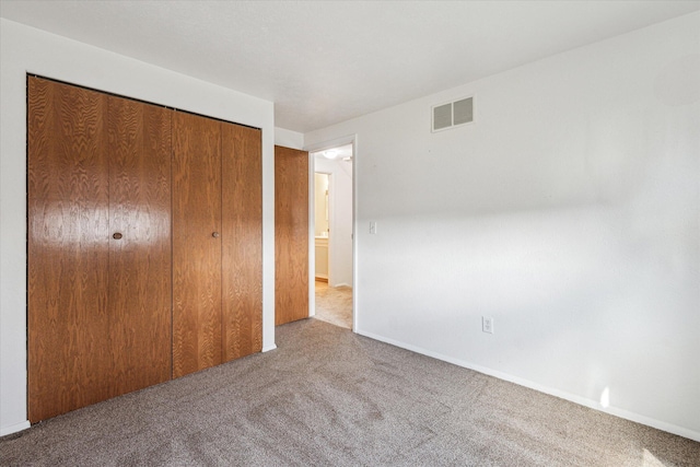 unfurnished bedroom with visible vents, baseboards, a closet, and carpet