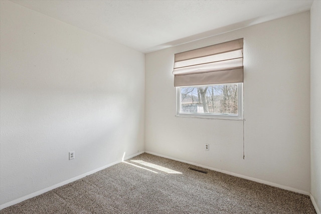 empty room featuring baseboards, carpet, and visible vents