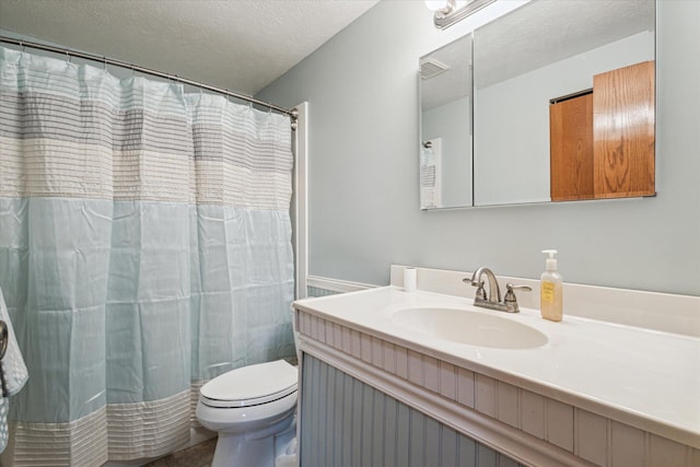 bathroom with a shower with shower curtain, vanity, a textured ceiling, and toilet