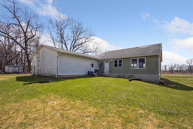 rear view of property with a yard and central air condition unit