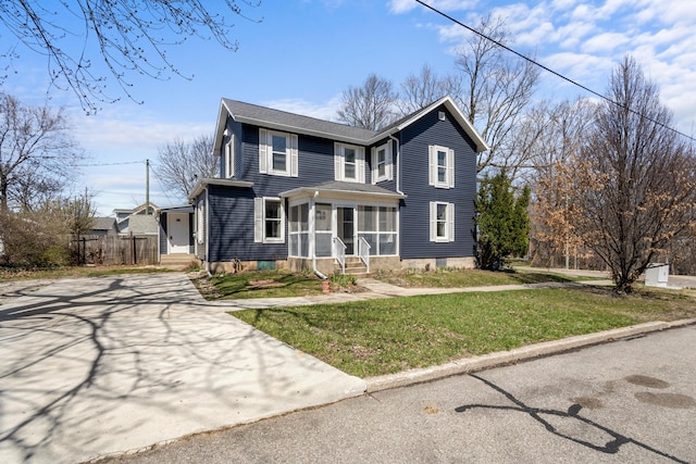 traditional-style house featuring entry steps, a front lawn, and concrete driveway