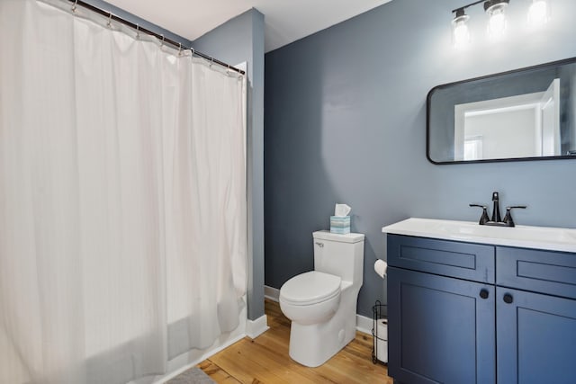 full bathroom featuring wood finished floors, vanity, and toilet