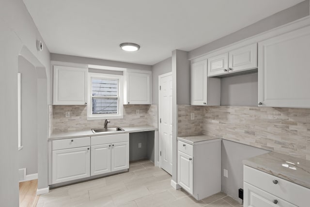19319 Huntington Rd, Detroit, MI 48219 - kitchen featuring light countertops, white cabinetry, decorative backsplash, and a sink