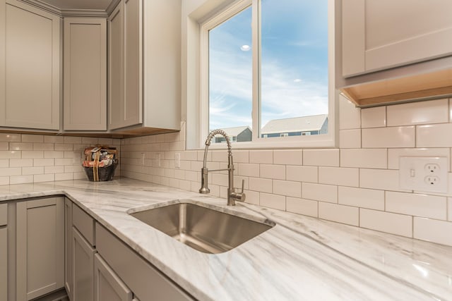 5192 Rolling Hills Dr, Grand Blanc, MI 48439 - kitchen featuring gray cabinets, decorative backsplash, light stone countertops, and a sink