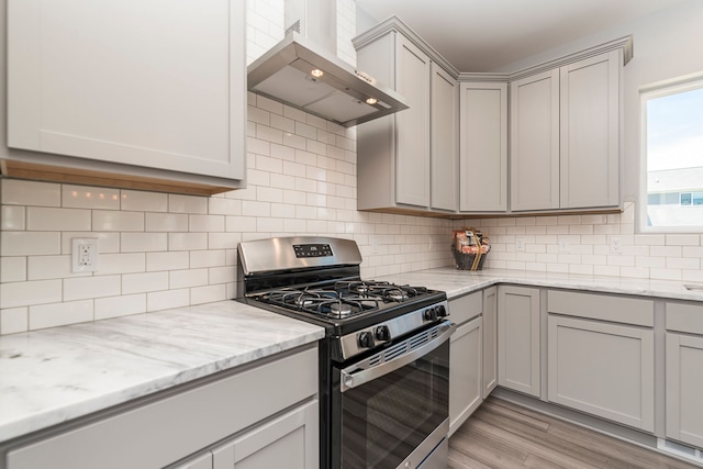 5192 Rolling Hills Dr, Grand Blanc, MI 48439 - kitchen featuring wall chimney exhaust hood, stainless steel range with gas cooktop, gray cabinetry, and light wood-style floors